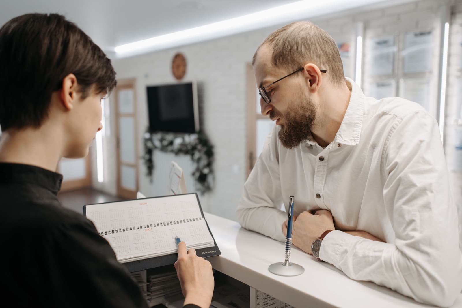 A patient discussing confusing healthcare paperwork at a clinic counter