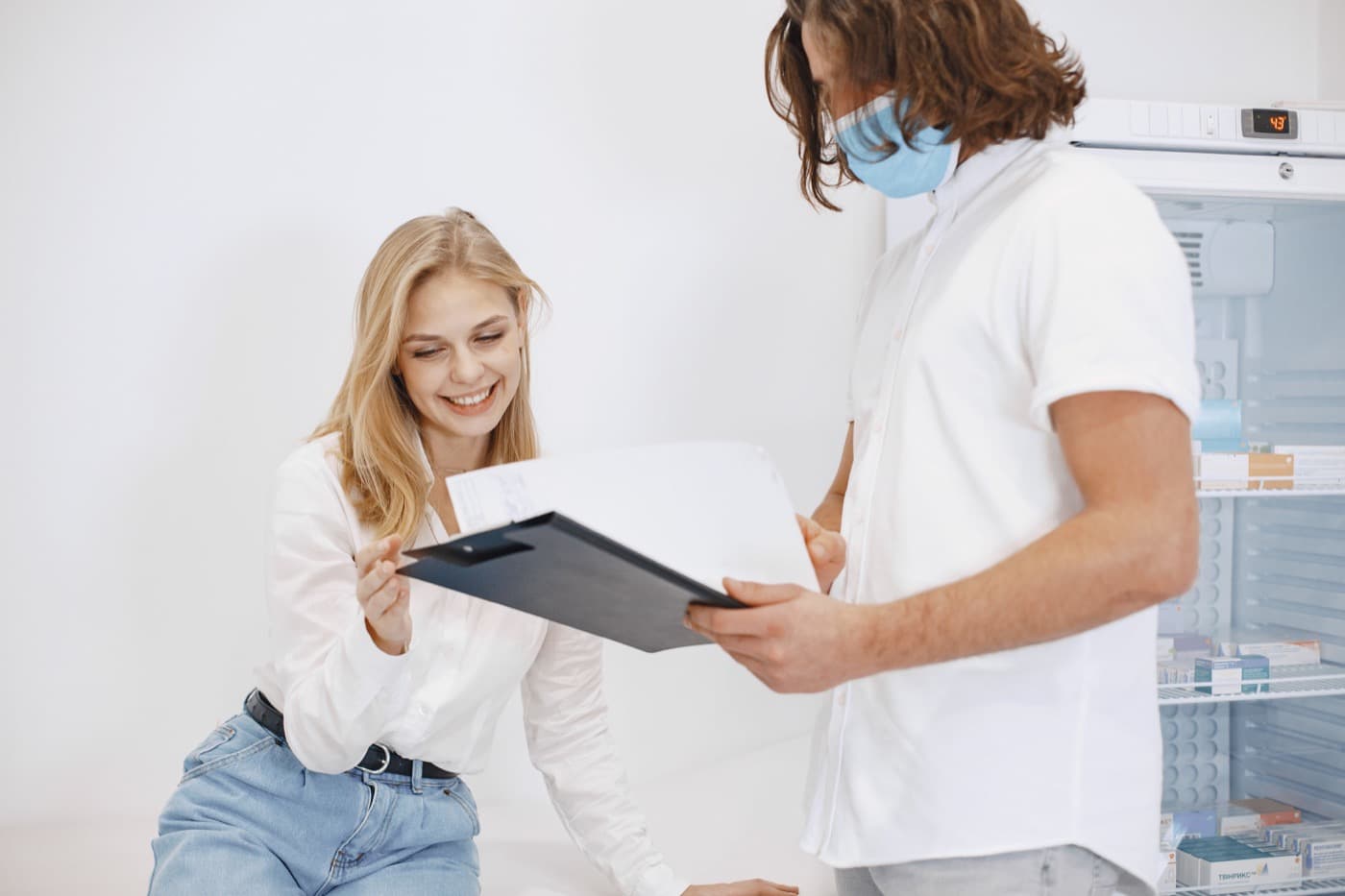 A patient and clinic staff member reviewing healthcare paperwork